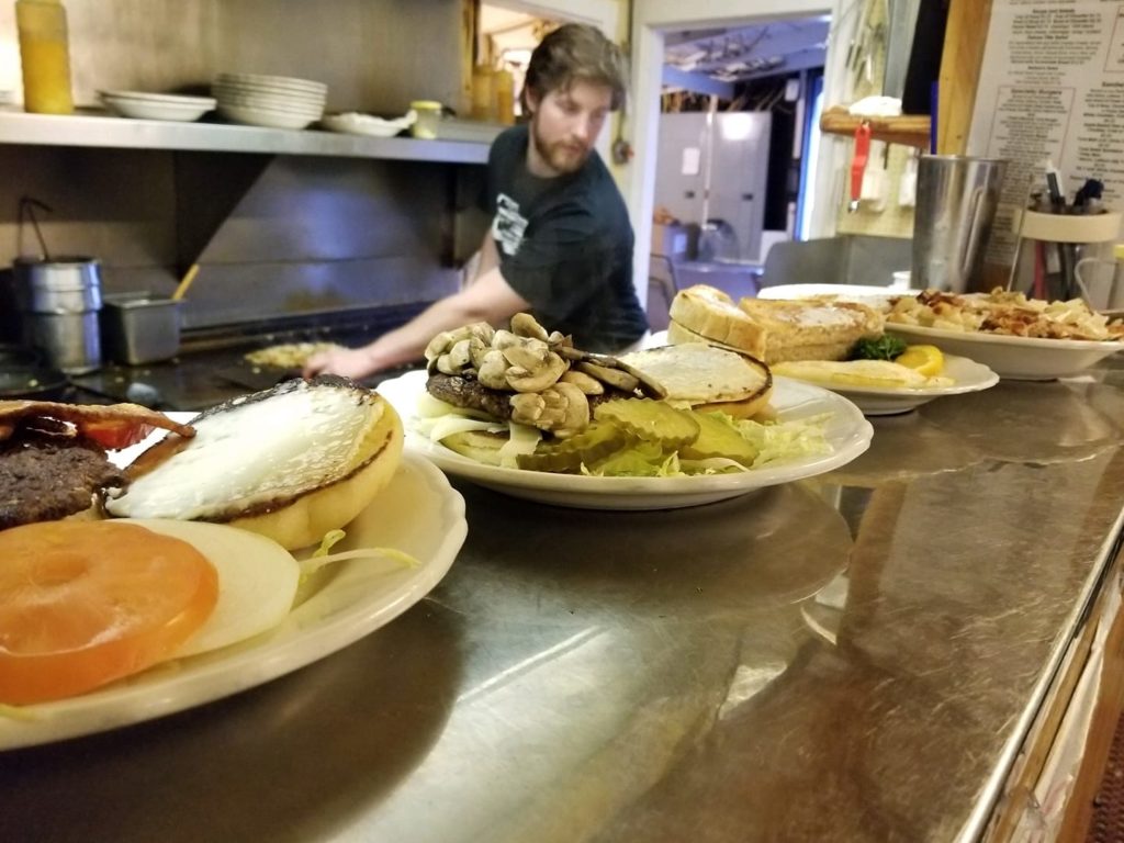 A look into the kitchen, a row of plates with food ready to be served