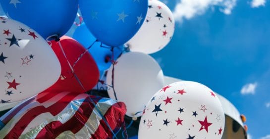 Photo of red, white and blue balloons with stars, and a red and white stripey ballon against a blue sky by Tom Dahm